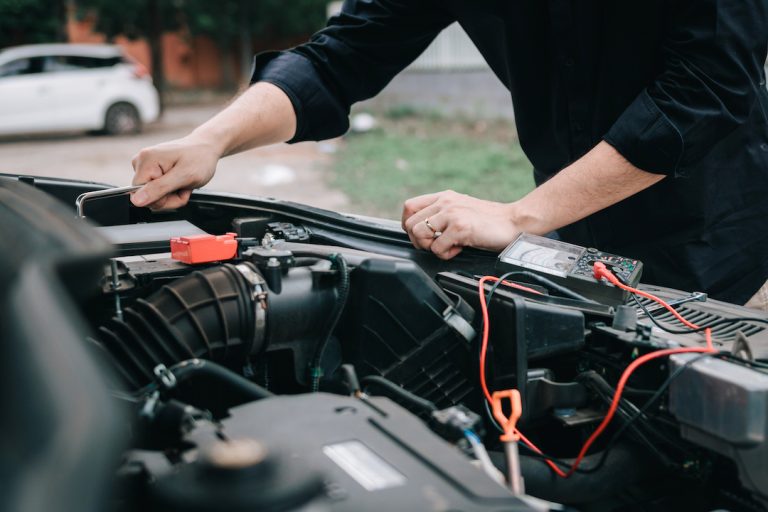 Car mechanic is checking the car battery for any faults