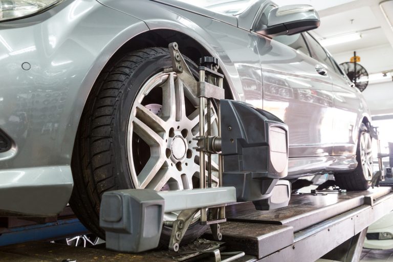 Closeup of car inside mechanics workshop with a clamped tire