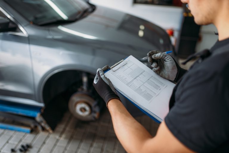 Mechanic does a tire inspection, car with no tyre